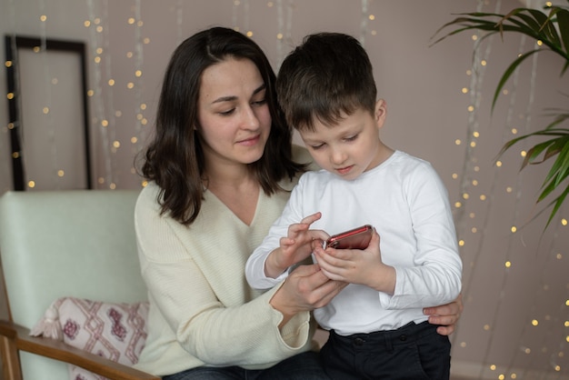 Mom and child are playing a mobile phone Mother and son