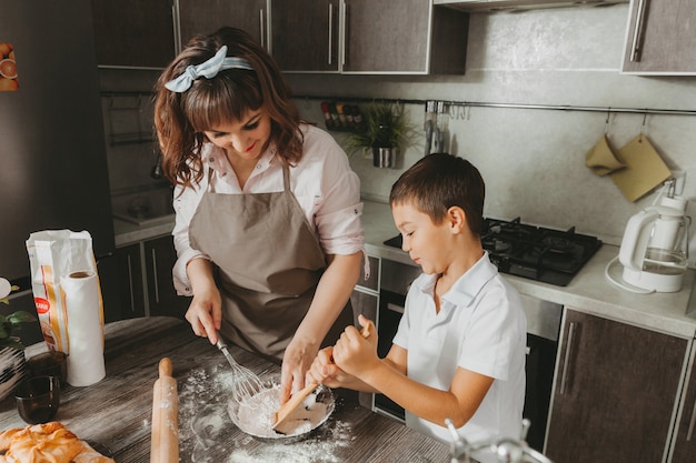 Mom and child prepare a birthday cake in the kitchen for Mother's Day, a series of pictures of everyday lifestyle in the interior from real life