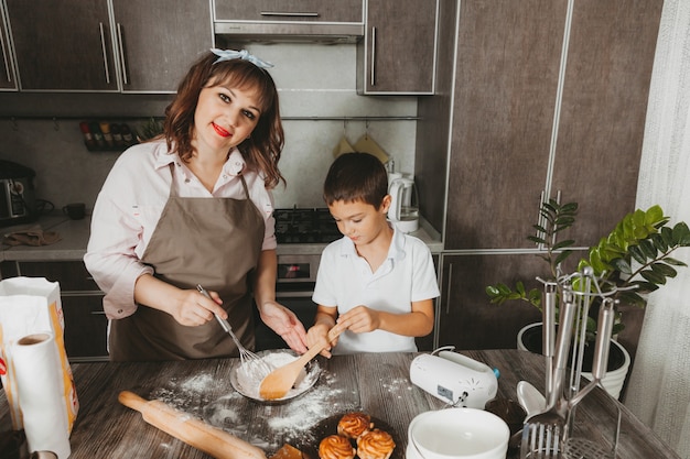 Mom and child prepare a birthday cake in the kitchen for Mother's Day, a series of pictures of everyday lifestyle in the interior from real life