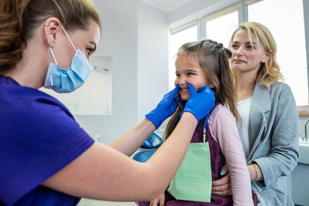 Mom and child visit their pediatric dentist Doctor talking with patient Healthcare