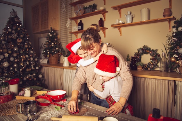 Mom and children are preparing cookies in the kitchen