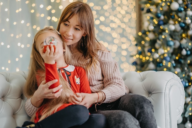 Mom and daughter are sitting together in the house, waiting for the Christmas magic. On the eve of Christmas with my mother.