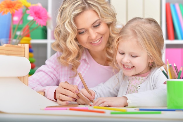 Mom and daughter draw at the table