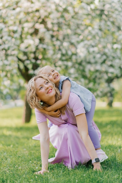 Mom and daughter have fun in the summer outdoors in the park