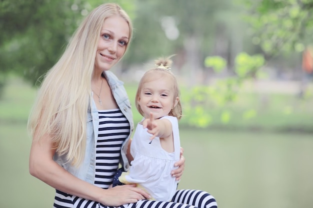 Mom and daughter having fun and playing in the summer park