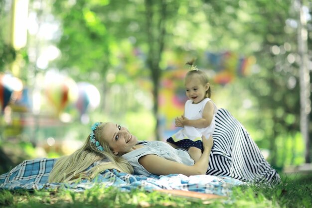 Mom and daughter having fun and playing in the summer park