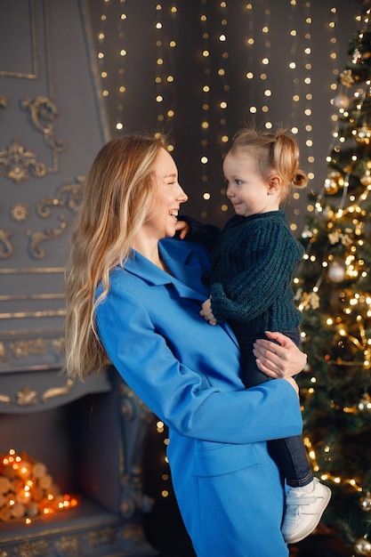 Mom and daughter hugging near Christmas tree