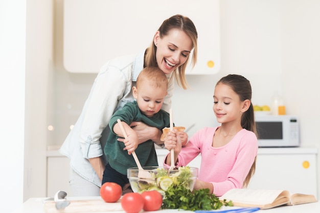 Mom daughter and little baby prepare a salad.