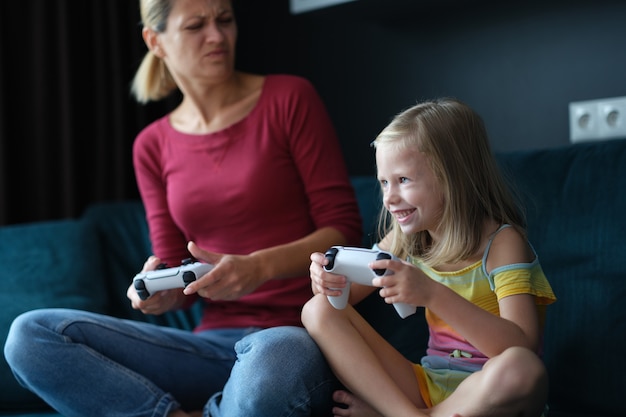 Mom and daughter play online games on console closeup