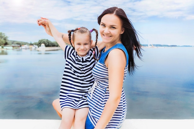 Mom and daughter relaxing by the lake