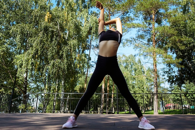 mom and daughter in sportswear on a sunny summer day on the embankment in the park doing fitness