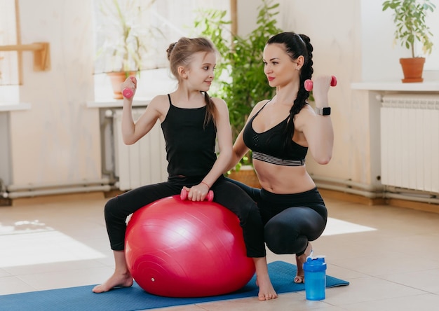 mom and daughter with dumbbells