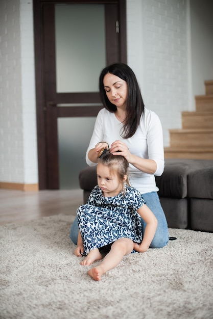 Mom does her daughter's hair in the morning