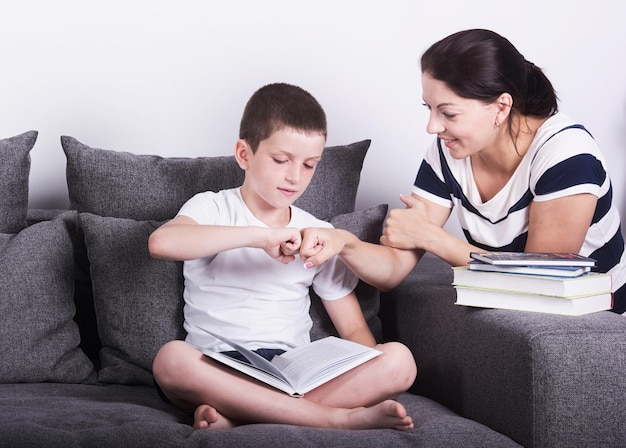 Mom encourages his son for reading a book Studio portrait on white background