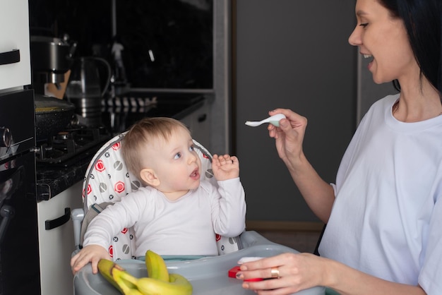 Mom feeds baby healthy food for small children maternity leave