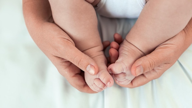 Mom hands holding newborn legs Beautiful conceptual image motherhood and baby