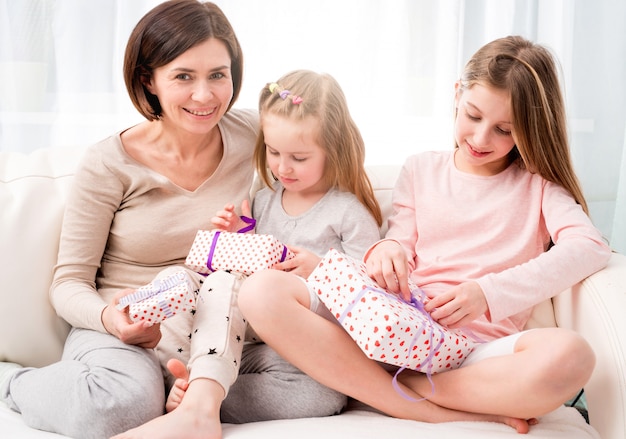 Mom and her daughters exchanging gifts