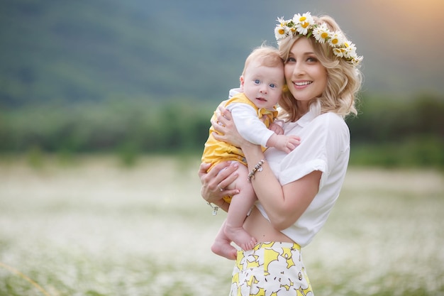 mom and her kid in camomile field