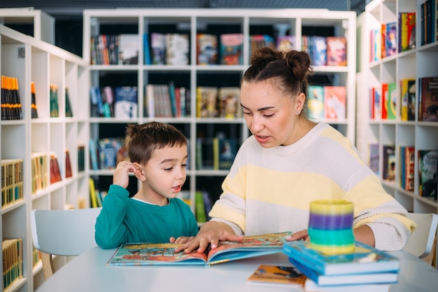 Mom and her little child the preschooler son read together childrens books