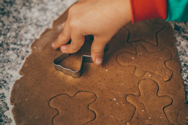 a mom and her son engage in the delightful task of preparing christmas gingerbread