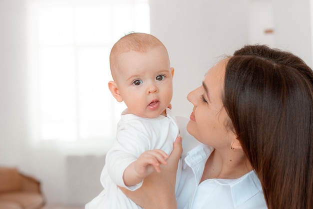 Mom holds the baby in her arms at home