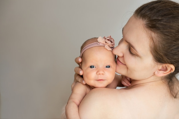 Mom holds the hand of a newborn baby.