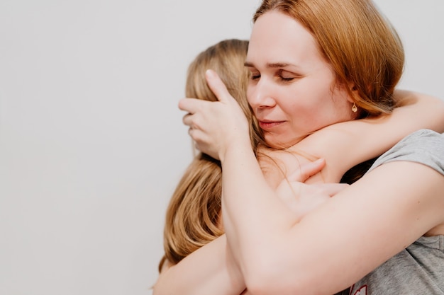 Mom hugs and comforts her little daughter. children's fears and tantrums. The girl is crying. motherly love and care.