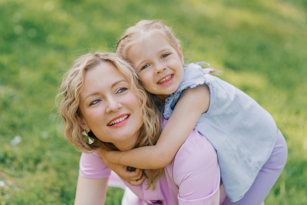 Mom and little daughter walk through the blooming spring garden and hug