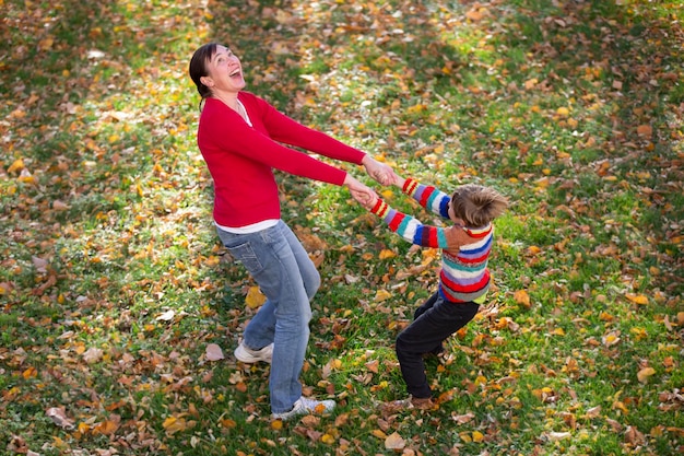 Mom and little son are walking in the autumn park