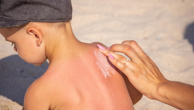 Mom puts sunscreen on Sin's back in the shape of a heart