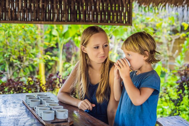 Mom and son are tasting different kinds of coffee and tea, including coffee Luwak.