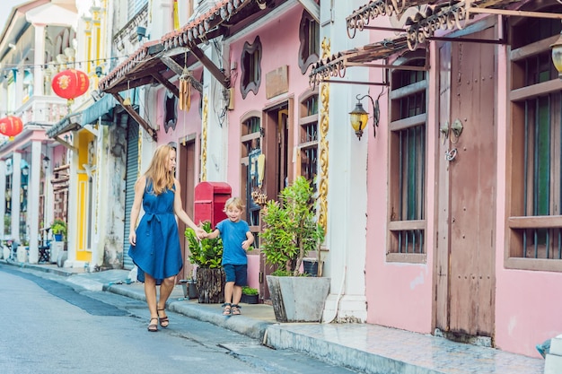 Mom and son are tourists on the street in the portugese style romani in phuket town also called