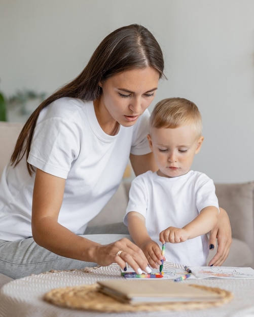 Mom and son at home in the living room hugging and playing parenthood of a young single mom and her