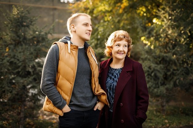 Mom and son look into the distance in the forest among the trees outdoors