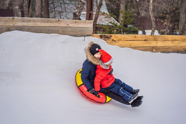 Mom son ride on an inflatable winter sled tubing Winter fun for the whole family