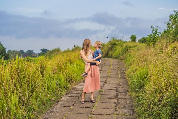 Mom and son tourists in Campuhan Ridge Walk , Scenic Green Valley in Ubud Bali. Traveling with children concept