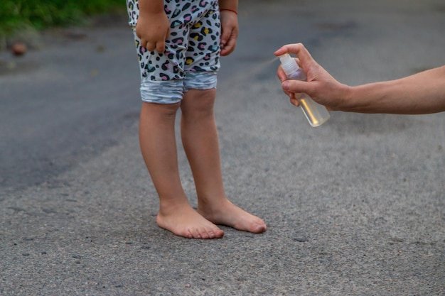 Mom sprays her child with mosquito repellent Selective focus