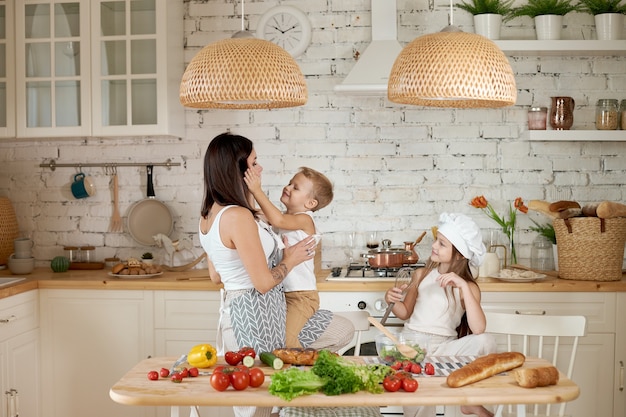 Mom teaches her daughter and son to prepare a Salad of fresh vegetables