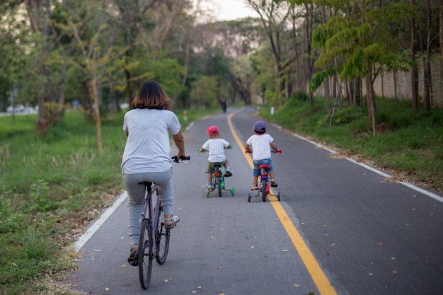 Mom and two son are riding bike on bike lane.