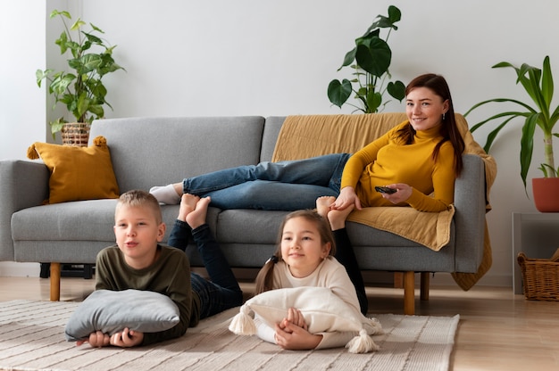 Mom watching television with her children