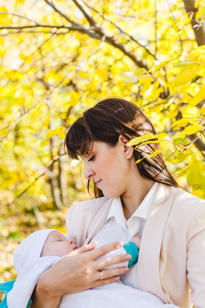 Mom with a baby, a small boy walks in the fall in the Park or forest. Yellow leaves, the beauty of nature. Communication between a child and a parent.