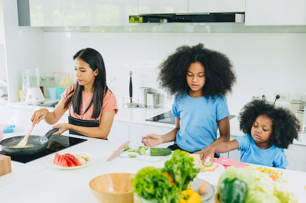 Mom with children cooking healthy food at home kitchen activity holiday