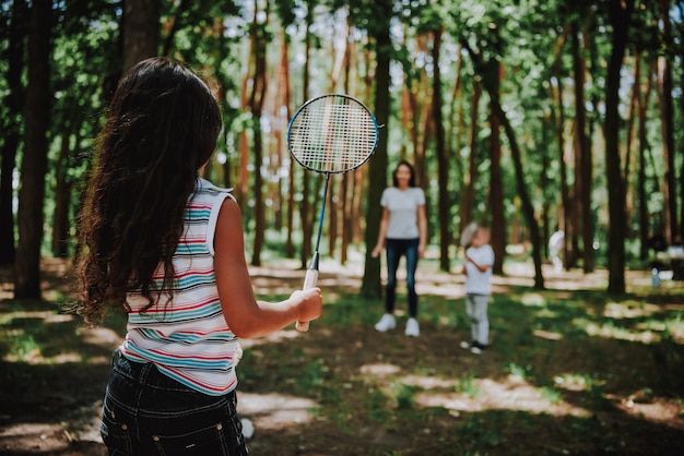 Mom with Children Playing Badminton in Sunny Park