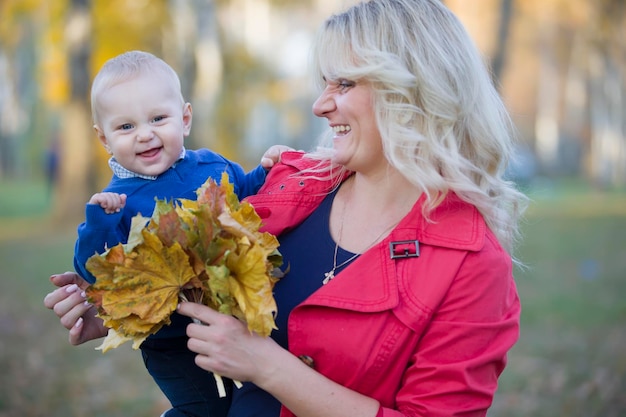 Mom with a toddler on a walk in the autumn park