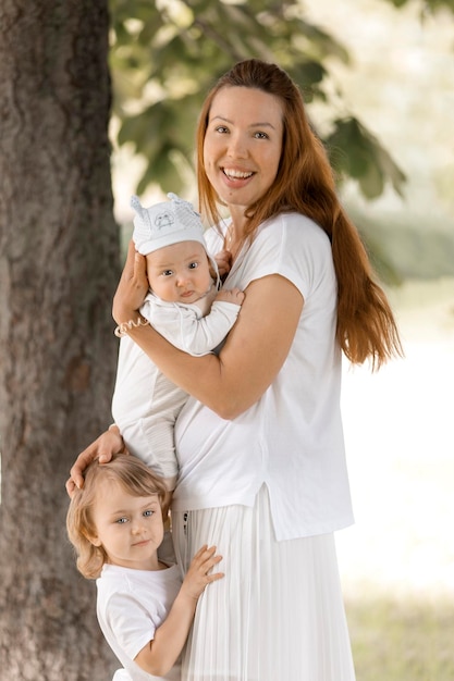 Mom woman and children at nature park in summer happy family play outside