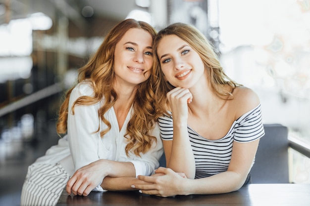 Mom and young beautiful daughter on a summer terrace