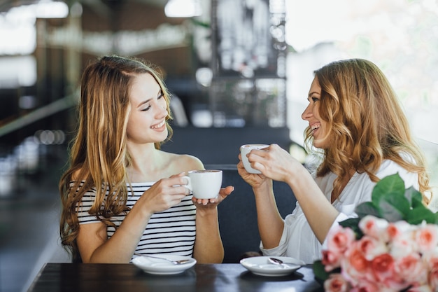 Mom and young beautiful daughter on a summer terrace