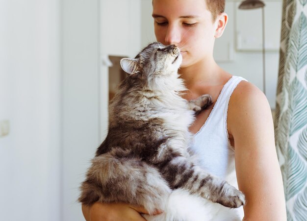 Moment joy, tenderness and love of teenager girl with domestic cat. teenage girl with short haircut