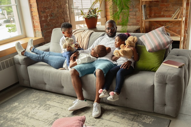 Moments Young and cheerful african family during quarantine insulation spending time