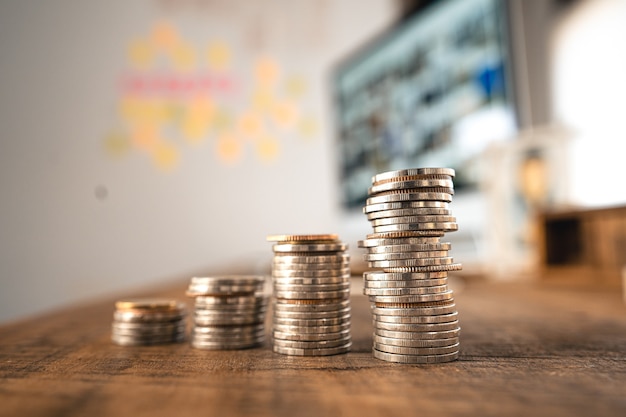 Money coin Grow up business and computer Concept, Silver coins stacked on wooden desks